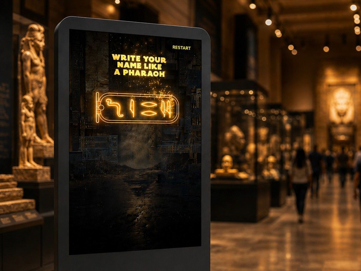 The finished visitor name displayed on screen as a glowing hieroglyph cartouche, ready to print