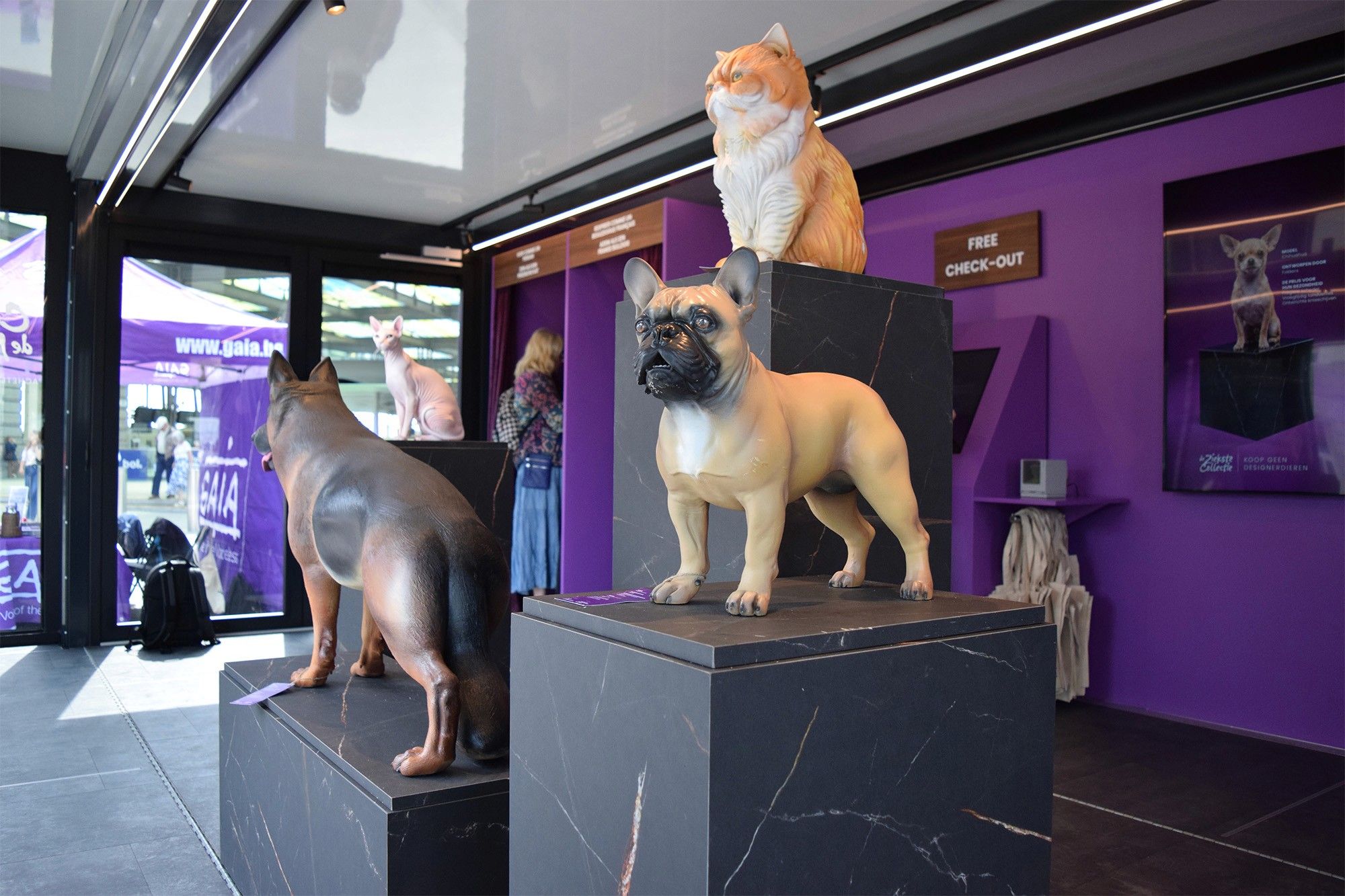 Life-size sculptures of a French bulldog, a Persian cat and a German shepherd on marble plinths inside the pavilion