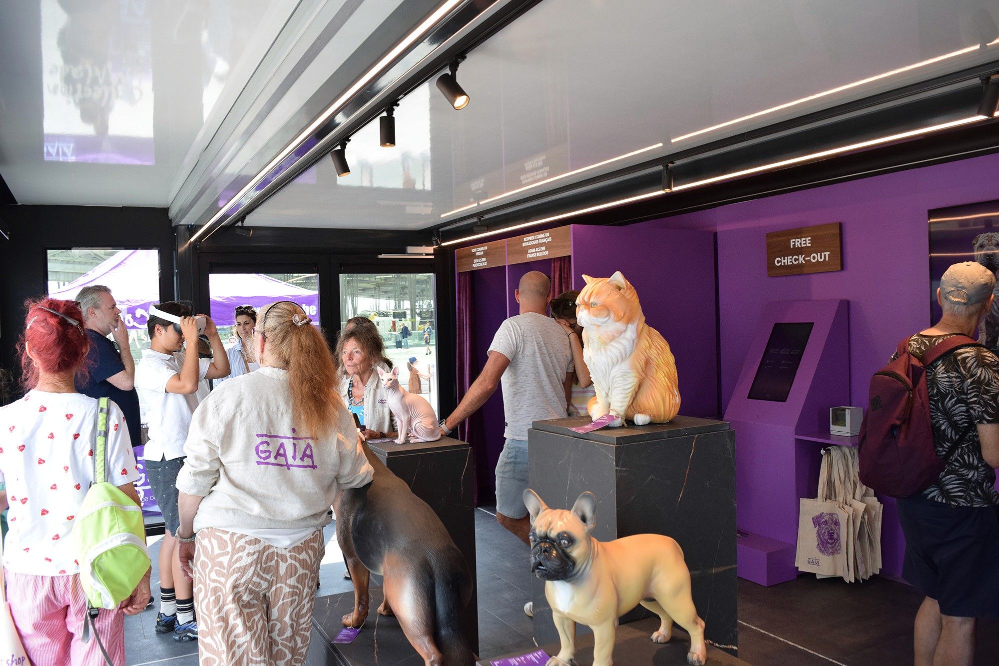Visitors moving through the pavilion past the sculptures and the free check-out counter